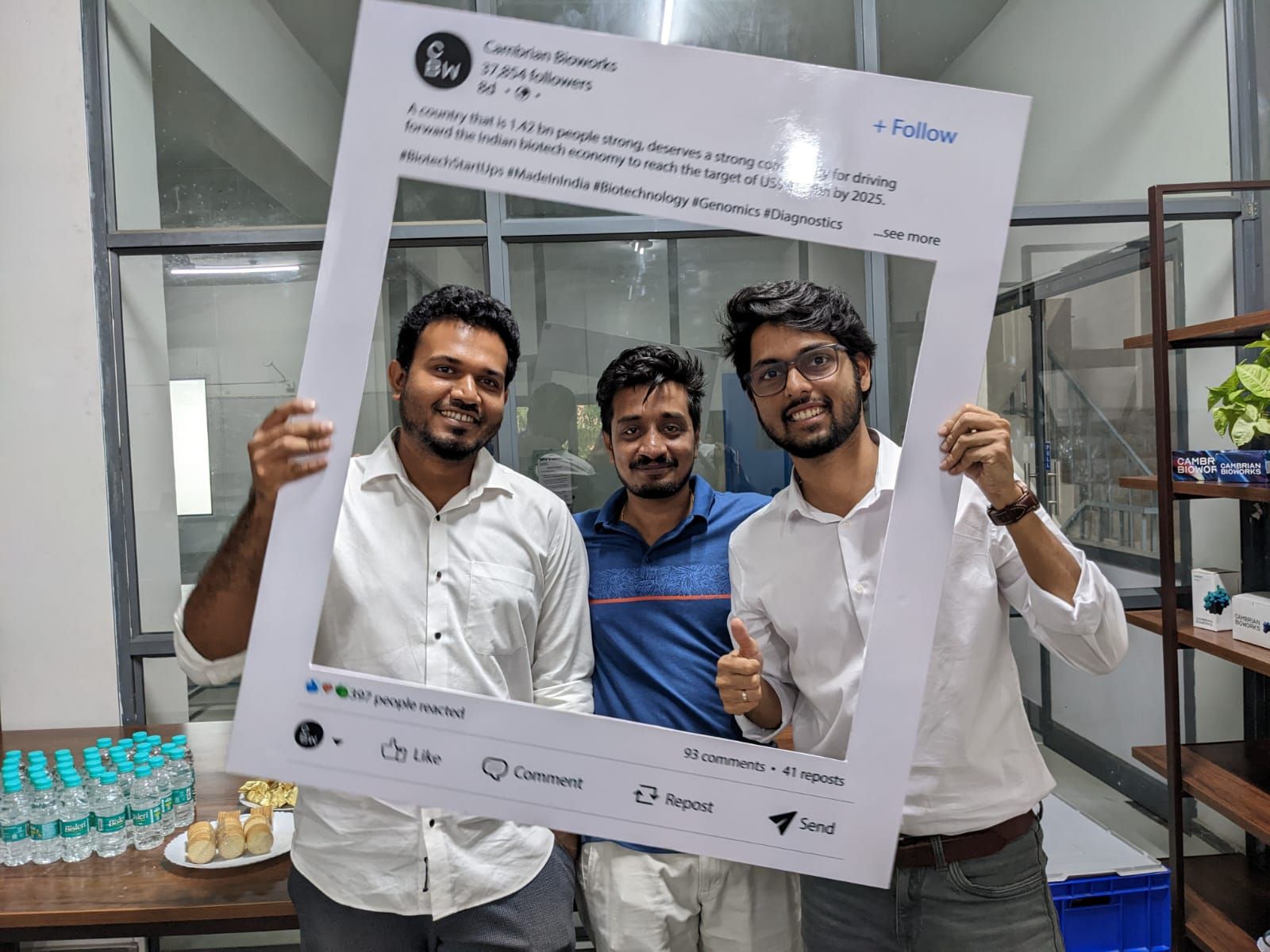 cambrian bioworks team holding social media frame prop stating their work in DNA diagnostics for cancer care treatments