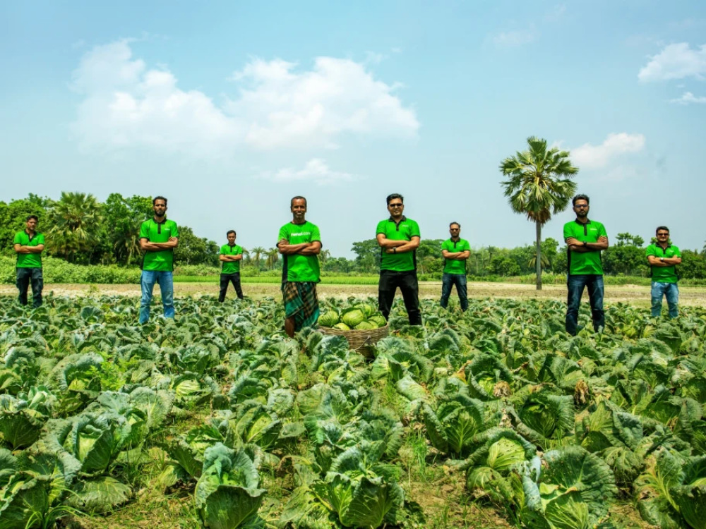 Fashol team on field surrounded by fresh produce from farmers